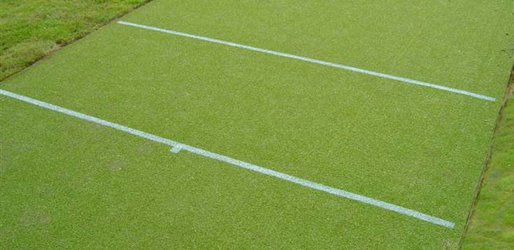 Creases marked on a cricket carpet with a white aerosol spray.